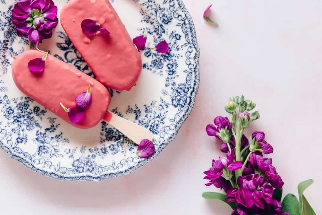 A photo of ice cream next to a pink flower on a pretty plate and 11 Healthy Dessert recipes you should try