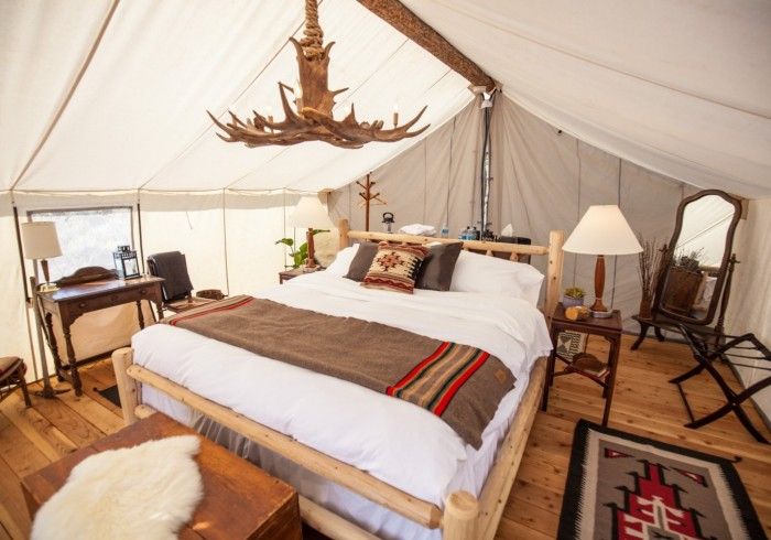 a photo of a bed in glamping tent and 5 seriously cool glamping spots to visit in 2023