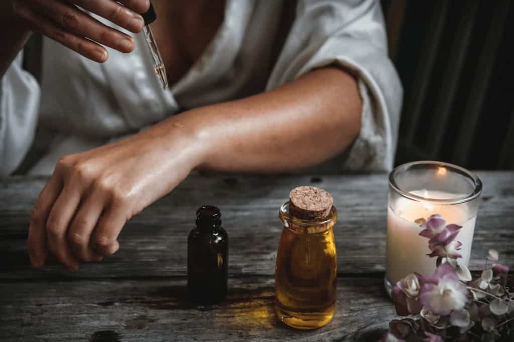 a photo of a woman using essential oils and best guided meditations for beginners.