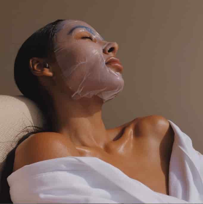 A photo of a woman wearing a sheet mask, relaxing and 5 best sheet masks for aging skin