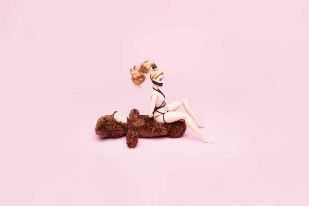 a photo of a bondage barbie riding a teddy in reverse cowgirl and orgasms after 40 oh yes
